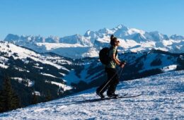 Femme faisant du ski de randonnée en hiver avec paysage montagnes derrière