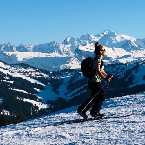 Femme faisant du ski de randonnée en hiver avec paysage montagnes derrière