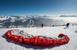 Homme préparant son parapente pour décoller en hiver