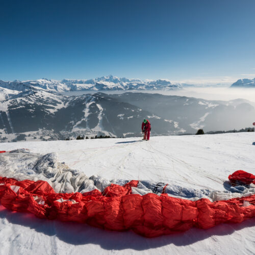 Homme préparant son parapente pour décoller en hiver