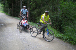 Three people riding MTBs, two of whom are Handi MTBs