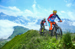 Hommes faisant du VTT en été sur les crêtes avec montagnes en fond